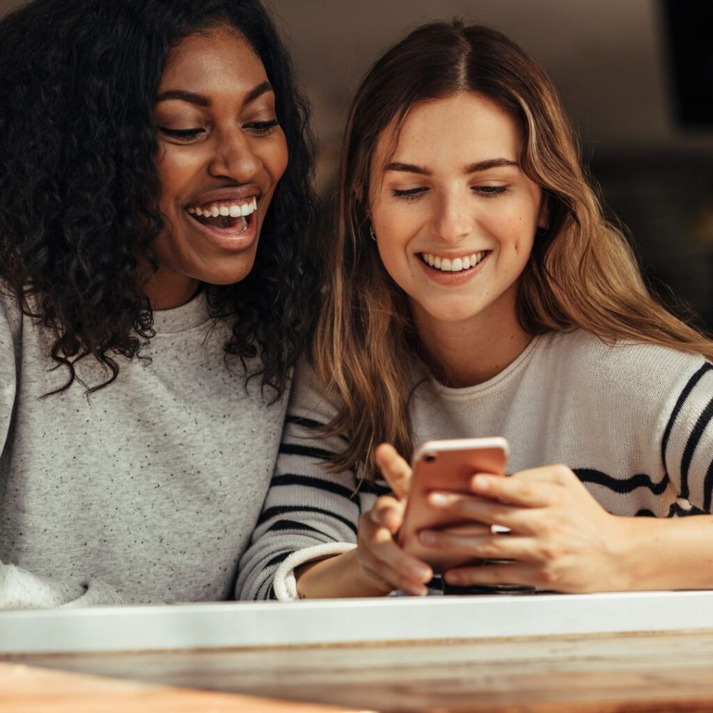 two girls looking at a phone