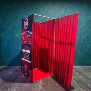 Bird's Eye View High Angle Photo Booth – Red and black branded overhead photobooth enclosure with a curtained entrance for private high-angle photo sessions.